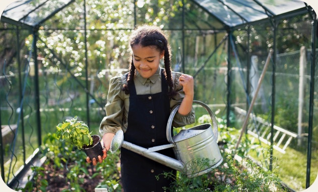 Child tending plants in a greenhouse